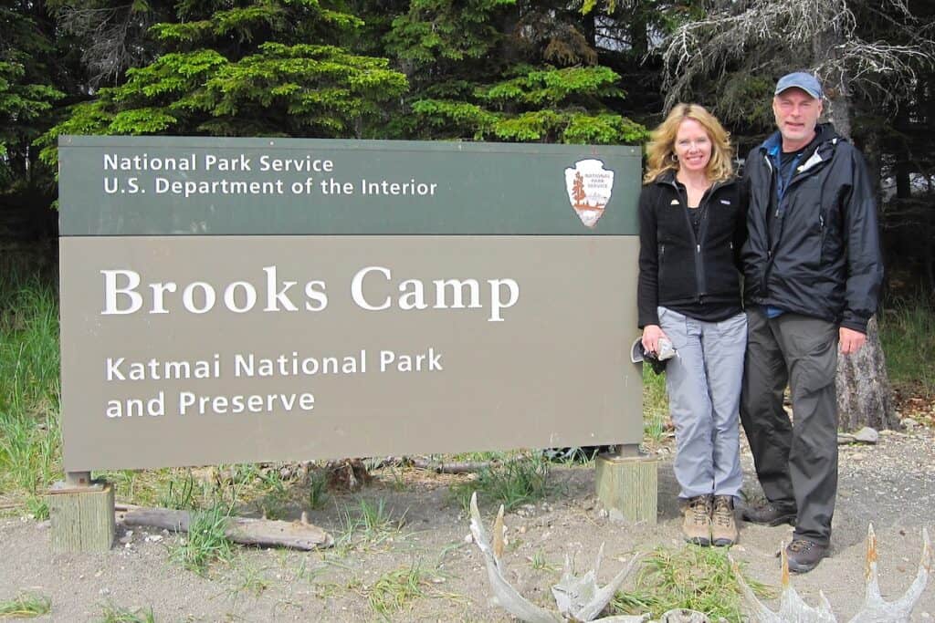 Matt and Karen stand next to the Brooks Camp sign in Katmai National Park