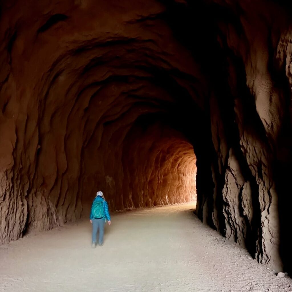 Woman walking in a historic railroad tunnel