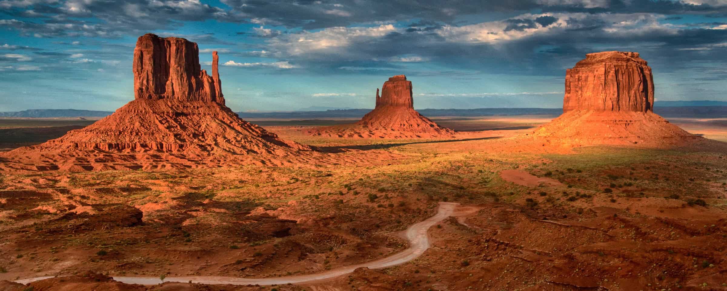 East and Mitten Mitten Buttes in Monument Valley with scenic drive road in the foreground