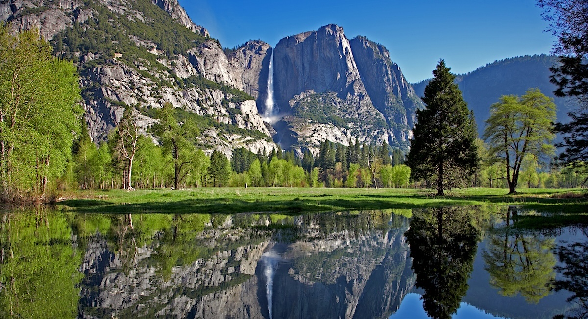 Yosemite fall in spring with a reflection of the waterfall and mountain in the river