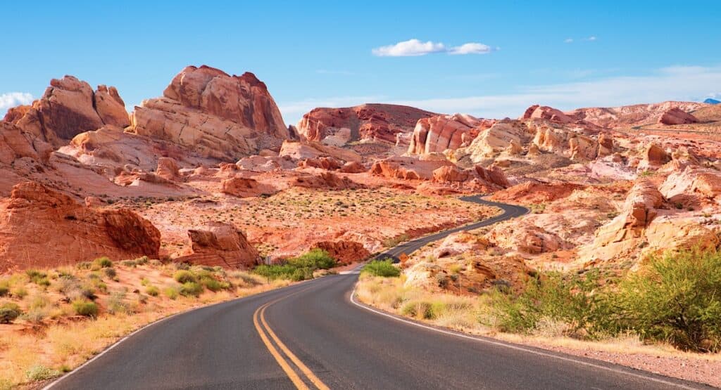 road winding through red rocks in desert