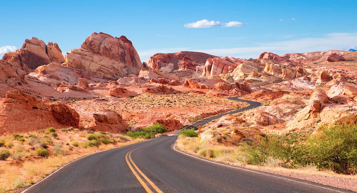road winding through red rocks in desert