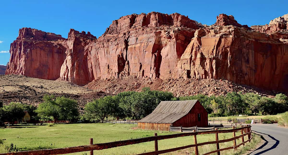a barn beneath red rock cliffs along Capitol Reef National Park Scenic Drive