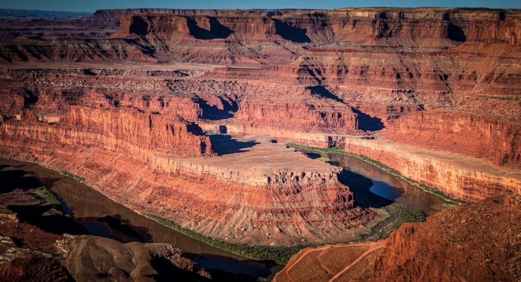 a river running through red rock canyons in the desert