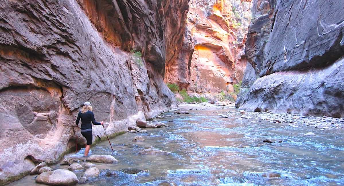 A woman walking in The Narrows section of the Virgin River in Zion National Park